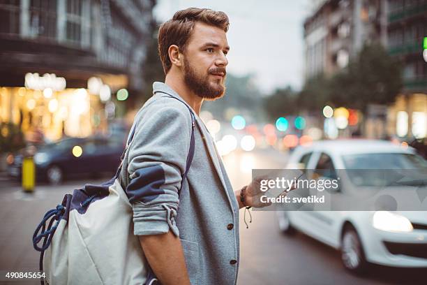 young man on the streets of big city. - mobile app car stock pictures, royalty-free photos & images