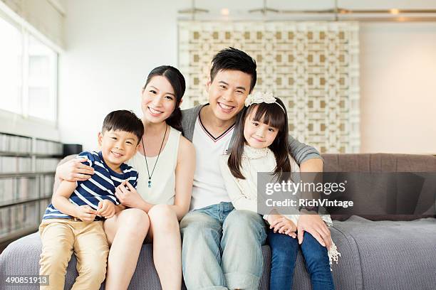 junge chinesische familie im apartment - chinese home stock-fotos und bilder