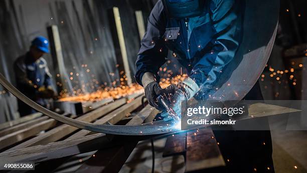 saldatore lavorando in officina - operaio metallurgico foto e immagini stock