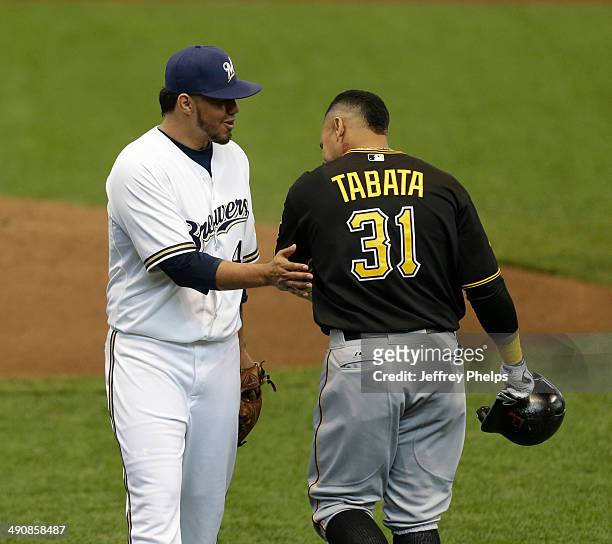 Yovani Gallardo of the Milwaukee Brewers taps the arm of Jose Tabata of the Pittsburgh Pirates after Tabata made an out in the second inning of a...