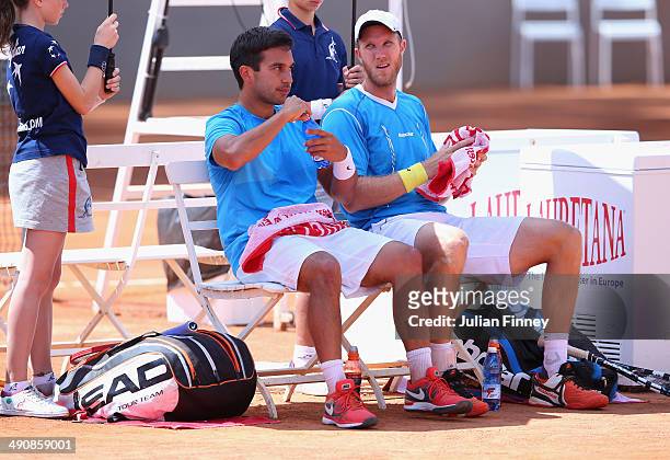 Treat Huey of Philiphines and Dominic Inglot of Great Britain take a break in their doubles match against Robin Haase of Holland and Feliciano Lopez...