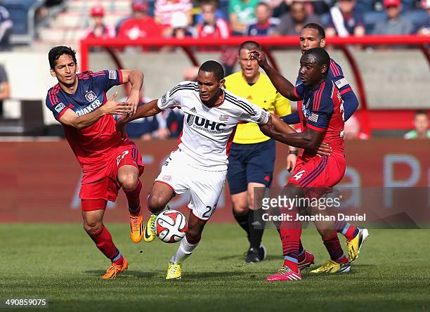 Victor Pineda and Jhon Kennedy Hurtado of the Chicago Fire try to hold back Jerry Bengtson of the New England Revolution during an MLS match at...