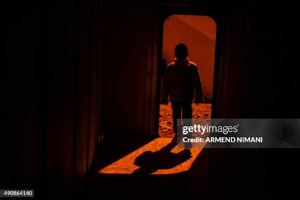 Boy's figure is silhouetted as he enters a tent as he arrives, along with other migrants and refugees, at the registration camp, after crossing the...