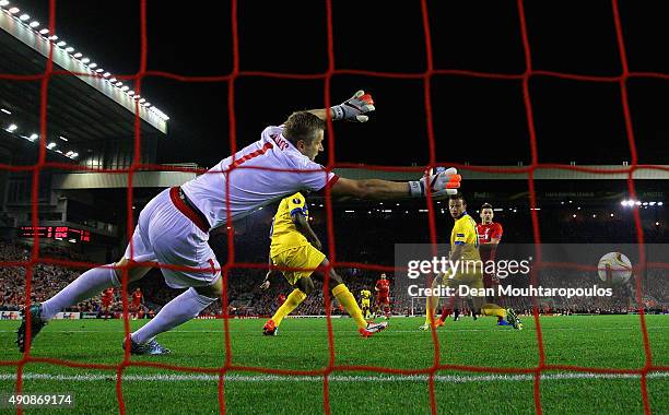 Adam Lallana of Liverpool scores the opening goal past Andris Vanins of FC Sion during the UEFA Europa League group B match between Liverpool FC and...