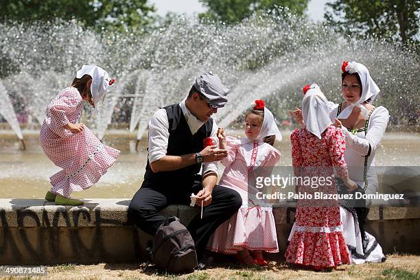 Family dressed as 'chulapos' have some food during the San Isidro festivities at Pradera de San Isidro park on May 15, 2014 in Madrid, Spain. During...
