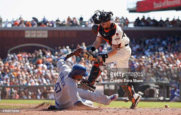 Howie Kendrick of the Los Angeles Dodgers slides safely past the tag of Trevor Brown of the San Francisco Giants to score on fielders choice hit by...
