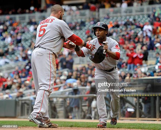 Jonny Gomes and Jonathan Herrera of the Boston Red Sox celebrate scoring against the Minnesota Twins during the ninth inning of the game on May 15,...