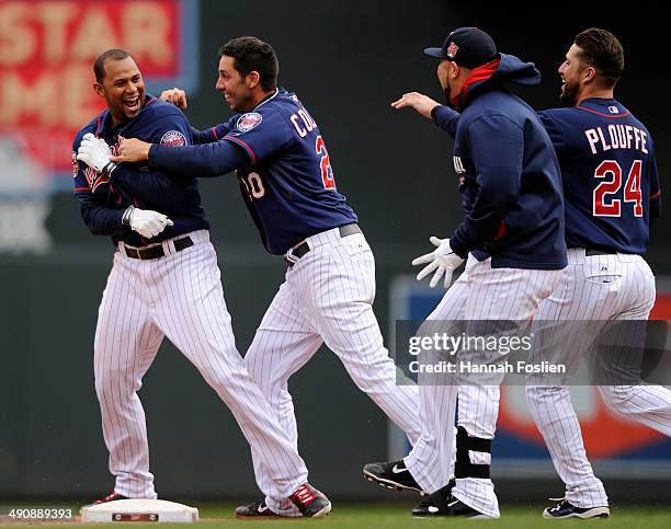 Aaron Hicks, Chris Colabello, Josmil Pinto and Trevor Plouffe of the Minnesota Twins celebrate a walk-off single by Hicks against the Boston Red Sox...