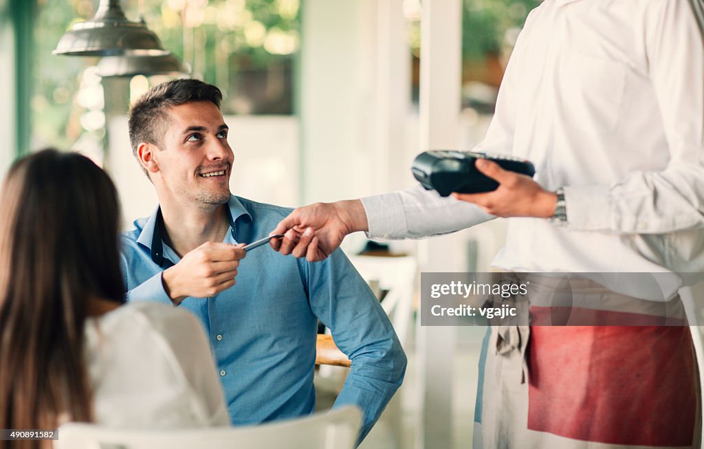 Man Paying Their Lunch With Credit Card In Restaurant.