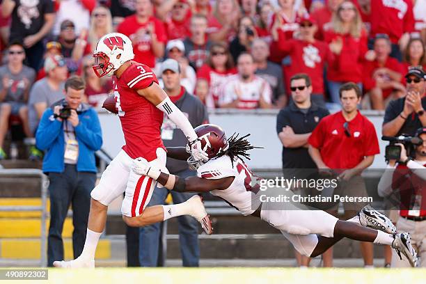 Tanner McEvoy of the Wisconsin Badgers runs with football past linebacker Terris Lewis of the Troy Trojans during the college football game at Camp...