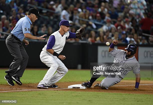 Wilin Rosario of the Colorado Rockies slides safely into third base as Jake Lamb of the Arizona Diamondbacks waits for the ball during the first...