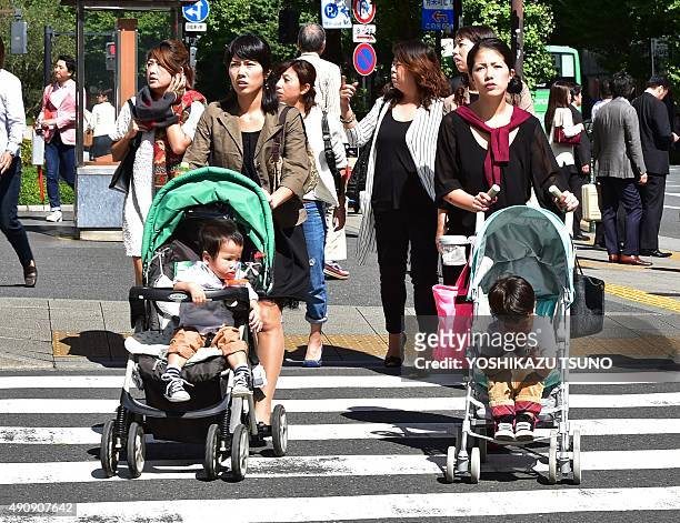 Japanese women push baby carts in Tokyo on October 2, 2015. Spending among Japanese households rebounded in August, offering a glimmer of hope after...