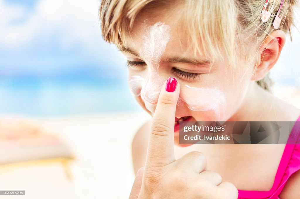 Applying sunscreen to child's face