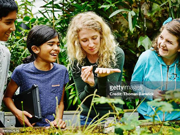 female botanist showing worms to young students - american influenced fotografías e imágenes de stock