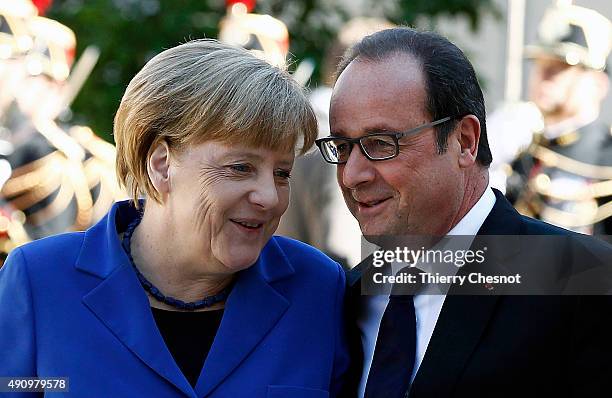 French President Francois Hollande welcomes German Chancellor Angela Merkel prior to their meeting at the Elysee Presidential Palace on October 02,...