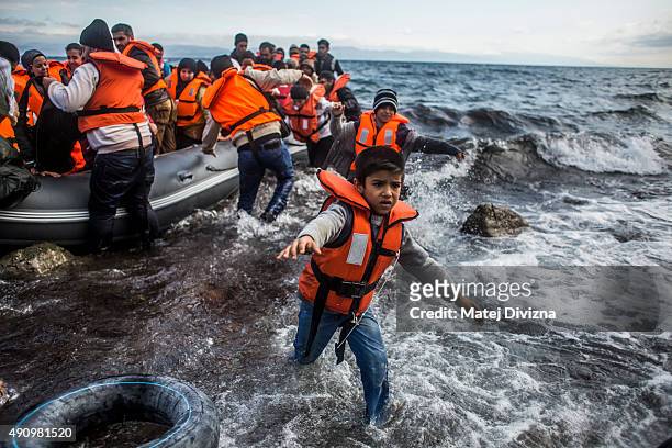 Refugees arrive on the shores of the Greek island of Lesbos after crossing the Aegean sea from Turkey on an inflatable boat on October 2, 2015 near...
