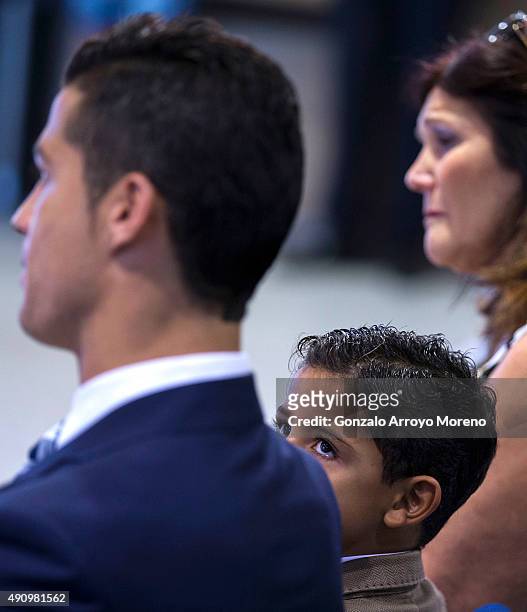 Cristiano Ronald JR looks to his father Cristiano Ronaldo next to his grandmother Maria Dolores dos Santos during Real Madrid CF president Florentino...