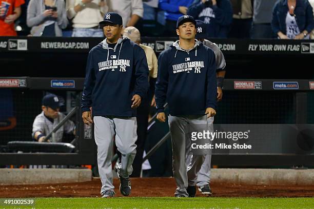 Masahiro Tanaka and Hiroki Kuroda of the New York Yankees walk out onto the field to celebrate after defeating the New York Mets on May 15, 2014 at...