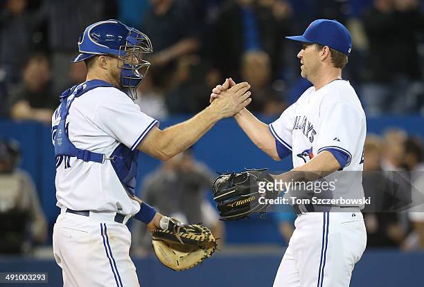 Casey Janssen of the Toronto Blue Jays celebrates with Erik Kratz after a victory against the Cleveland Indians on May 15, 2014 at Rogers Centre in...