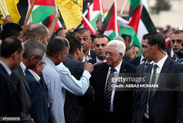 Palestinians wave their national flags as they greet their president Mahmud Abbas upon his arrival from New York on October 2, 2015 where he attended...