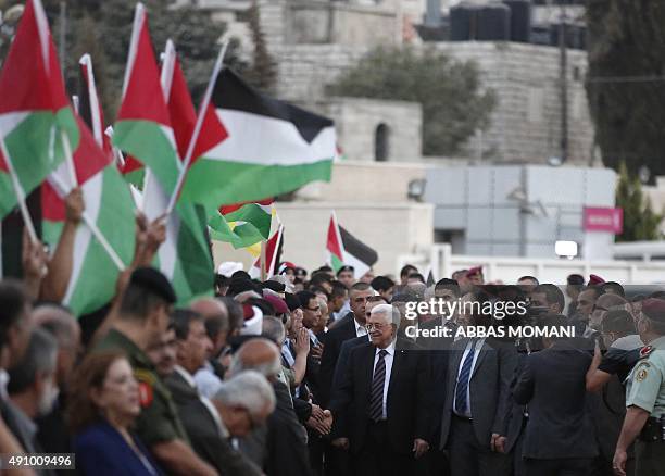 Palestinians wave their national flags as they greet their president Mahmud Abbas upon his arrival from New York on October 2, 2015 where he attended...