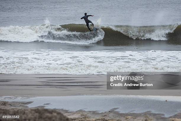 Surfer rides a wave during the potential build up to Hurricane Joaquin on October 2, 2015 in Long Beach, New York. The category 4 storm is currently...