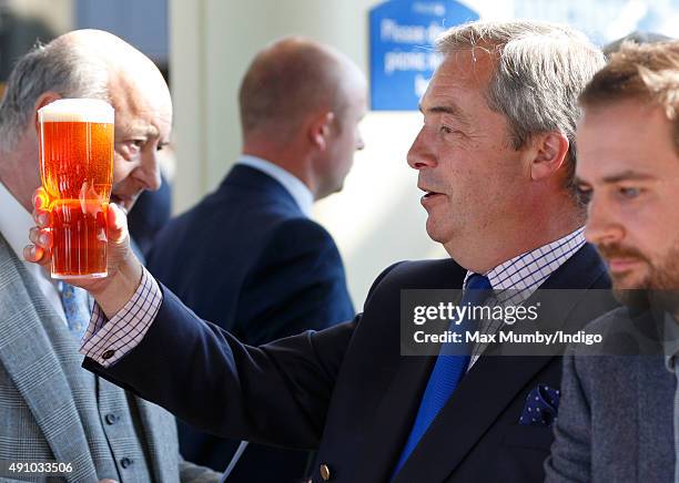 Nigel Farage drinks a beer as he attends the Autumn Racing & CAMRA Beer Festival meet at Ascot Racecourse on October 2, 2015 in Ascot, England.