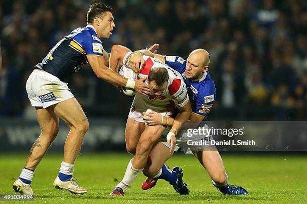 Carl Ablett and Joel Moon of Leeds Rhinos tackles James Roby of St. Helens R.F.C during the First Utility Super League Semi Final between Leeds...