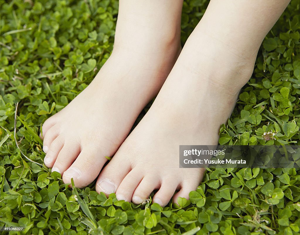 Foot of young girl on green grass