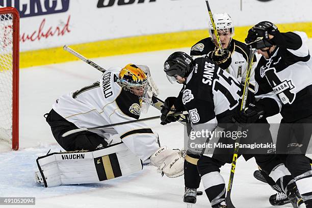 Goaltender Mason McDonald of the Charlottetown Islanders reaches to smother the puck with his glove during the QMJHL game against the...