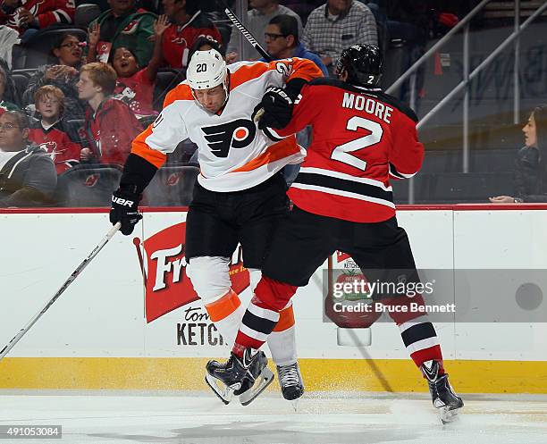 Umberger of the Philadelphia Flyers steps into John Moore of the New Jersey Devils during the third period at the Prudential Center on October 2,...