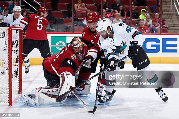 Joel Ward of the San Jose Sharks attempts a shot against goaltender Mike Smith of the Arizona Coyotes as Shane Doan defends during the second period...