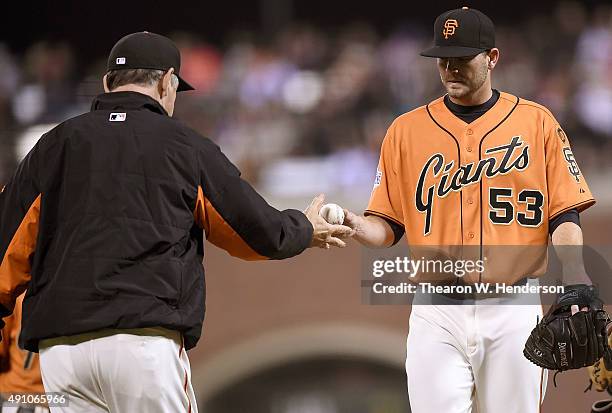 Manager Bruce Bochy of the San Francisco Giants takes the ball from starting pitcher Chris Heston taking him out of the game against the Colorado...