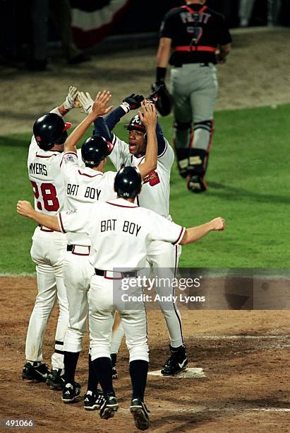 The Atlanta Braves celebrate as Gerald Williams crosses home plate during the National League Championship Series game six against the New York Mets...