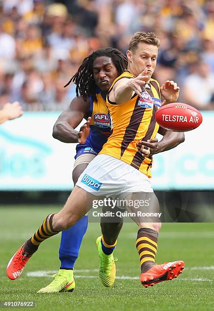 Sam Mitchell of the Hawks kicks whilst being tackled Nic Naitanui of the Eagles during the 2015 AFL Grand Final match between the Hawthorn Hawks and...