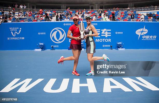 Martina Hingis of Switzerland and Sania Mirza of India pose for a picture with their trophy on day 7 of 2015 Dongfeng Motor Wuhan Open at Optics...
