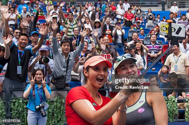 Martina Hingis of Switzerland and Sania Mirza of India take a selfie with spectators of Wuhan after winning their match on day 7 of 2015 Dongfeng...