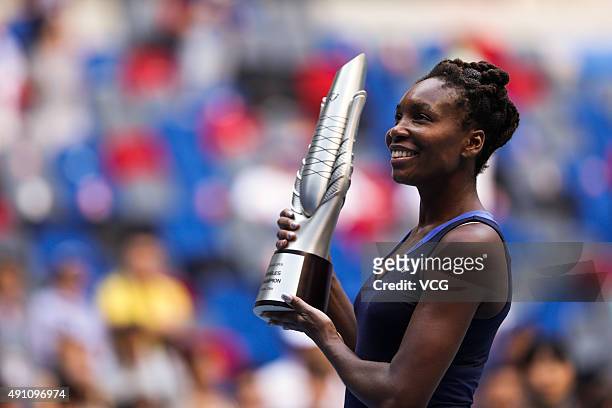 Venus Williams of the United States poses with her trophy after winning the women's singles final against Garbine Muguruza of Spain during day 7 of...