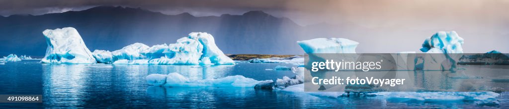 Blue icebergs floating along storm Arctic coast panorama Jokulsarlon Iceland