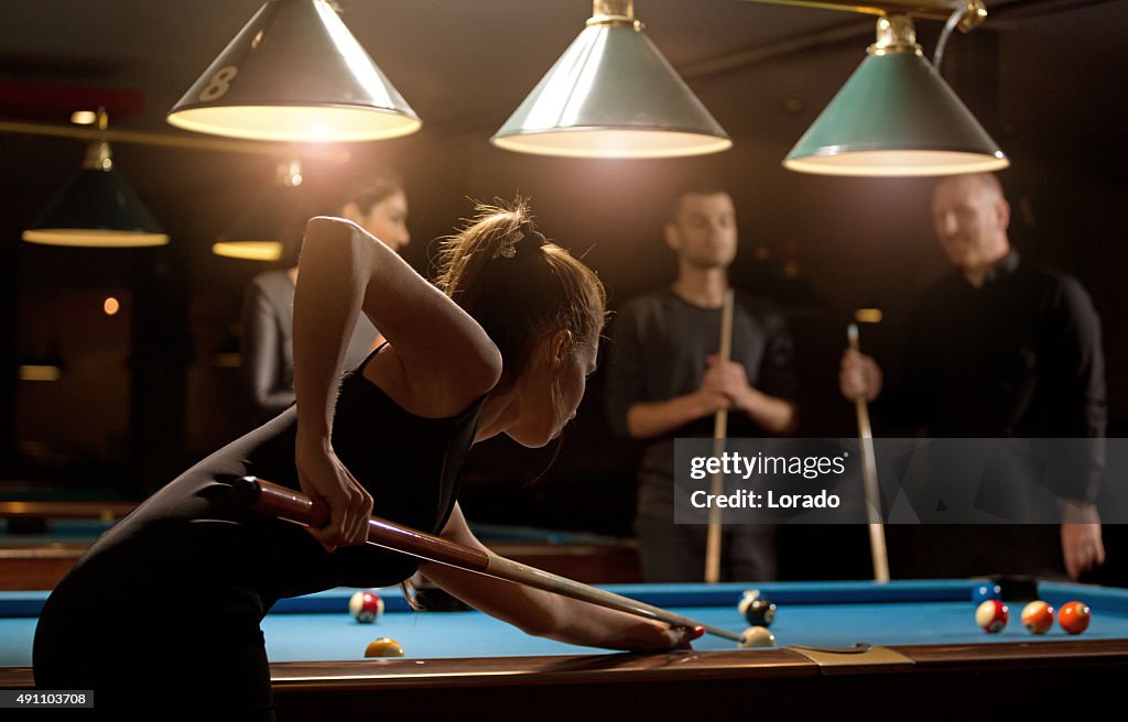 Frau spielt pool mit Gruppe von Freunden