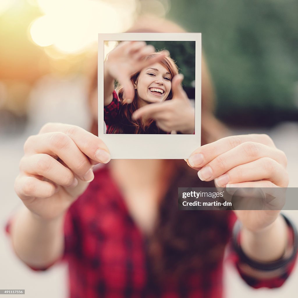 Girl holding instant selfie