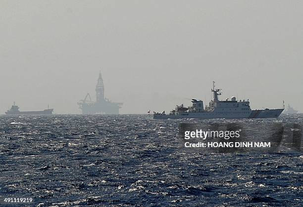 This picture taken on May 14, 2014 from a Vietnamese coast guard ship shows a Chinese coast guard vessel sailing near China's oil drilling rig in...
