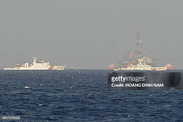 This picture taken on May 14, 2014 from a Vietnamese coast guard ship shows Chinese coast guard vessels sailing near China's oil drilling rig in...
