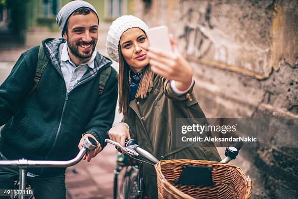 souriant selfie sur un vélo - trench stock photos et images de collection