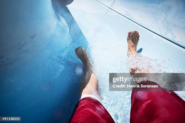 man in a water slide - ウォータースライダー ストックフォトと画像