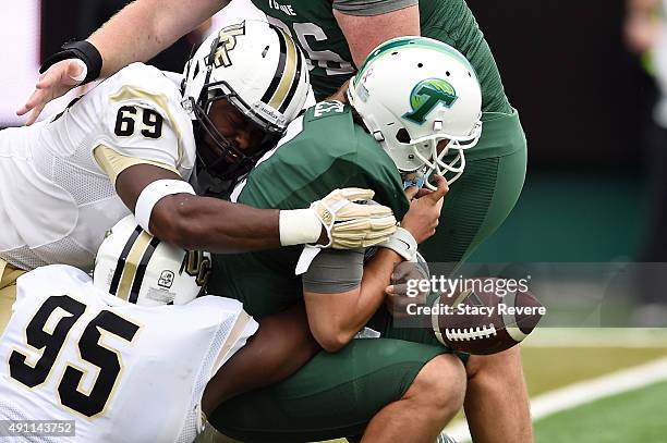 Tanner Lee of the Tulane Green Wave loses the ball after being sacked by Thomas Niles and Jamiyus Pittman of the UCF Knights during the first quarter...
