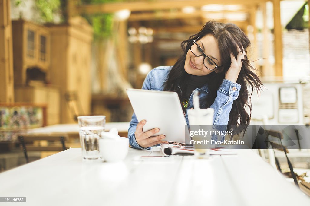 Junge Frau arbeitet auf Ihrem tablet-PC in einem Café