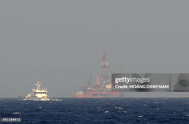 This picture taken on May 14, 2014 from a Vietnamese coast guard ship shows a Chinese coast guard vessel sailing near China's oil drilling rig in...