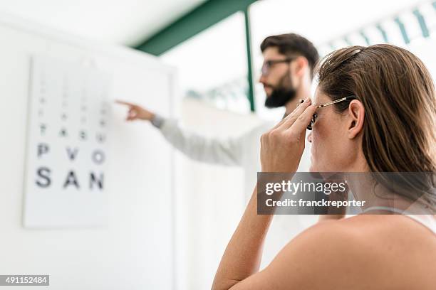 ophthalmologist doctor with the snellen chart - ophthalmologist chart stock pictures, royalty-free photos & images