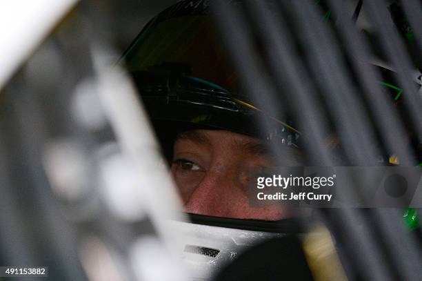 Kyle Busch, driver of the Interstate Batteries Toyota, sits in his car in the garage area during practice for the NASCAR Sprint Cup Series AAA 400 at...